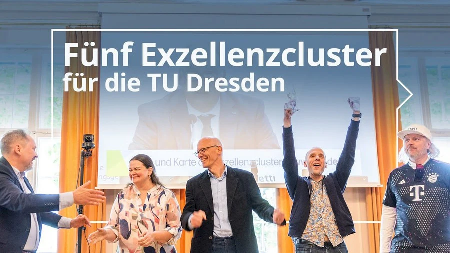 © TUD Picture of 5 cheering people in front of a video of a press conference projected on the wall